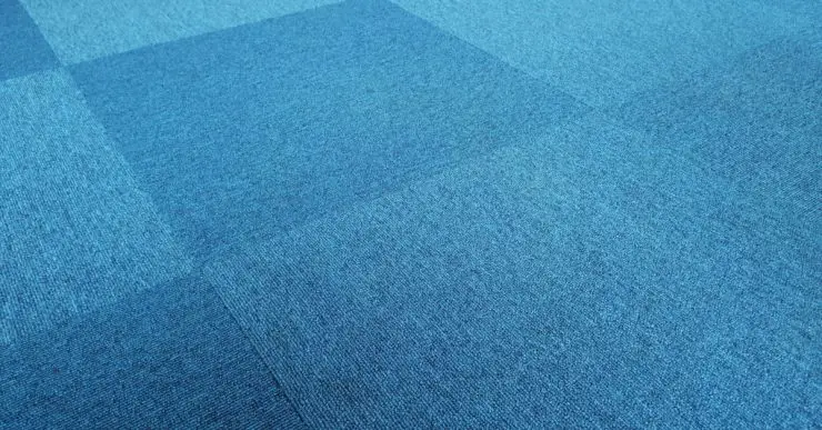 Un revêtement de sol en tapis bleu, motif carreau