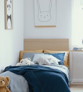 Chambre d'enfants avec un nounours au pied du lit