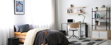 Une chambre d'adolescent avec une guitare adossée sur le lit