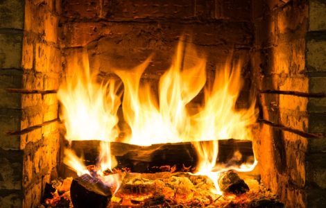 Zoom sur le bois de chauffage qui brûle dans une cheminée en briques