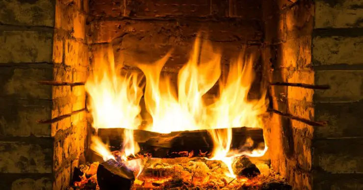 Zoom sur le bois de chauffage qui brûle dans une cheminée en briques