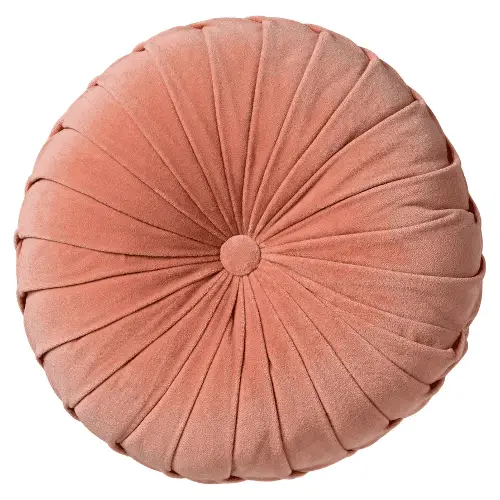 Un coussin rond rose saumon en velours