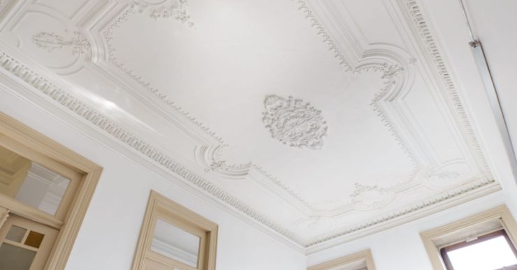 Vue sur le plafond blanc orné de belles moulures