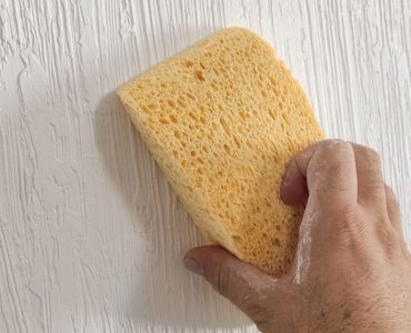 Zoom sur une main appliquant de la peinture à l'éponge