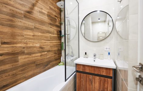 Petite salle de bain avec baignoire protégée par une cloison vitrée