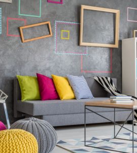 Grand salon moderne avec un canapé gris et des oreillers et poufs colorés