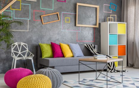 Grand salon moderne avec un canapé gris et des oreillers et poufs colorés