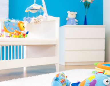 Une chambre bébé tout en couleur avec des jouets sur un tapis blanc