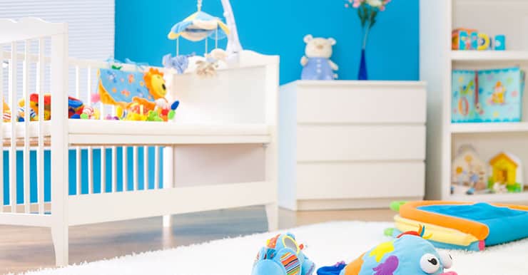 Une chambre bébé tout en couleur avec des jouets sur un tapis blanc