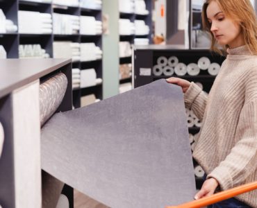 Une jeune femme en train de choisir du papier peint dans un magasin