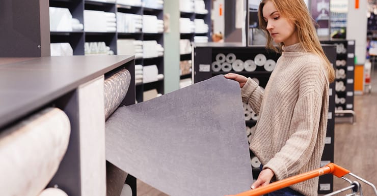 Une jeune femme en train de choisir du papier peint dans un magasin