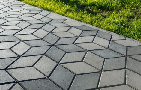 Un sentier pavé de tuiles de béton en forme de losange