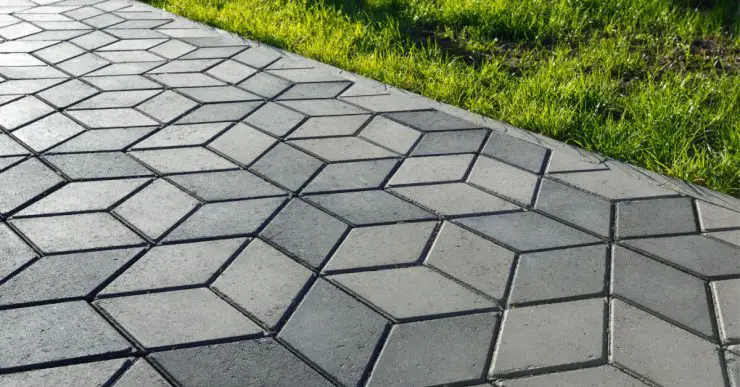 Un sentier pavé de tuiles de béton en forme de losange