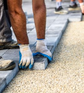 Deux hommes installent de nouvelles dalles pour l'allée