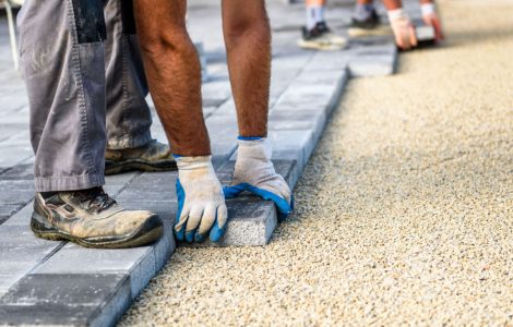Deux hommes installent de nouvelles dalles pour l'allée