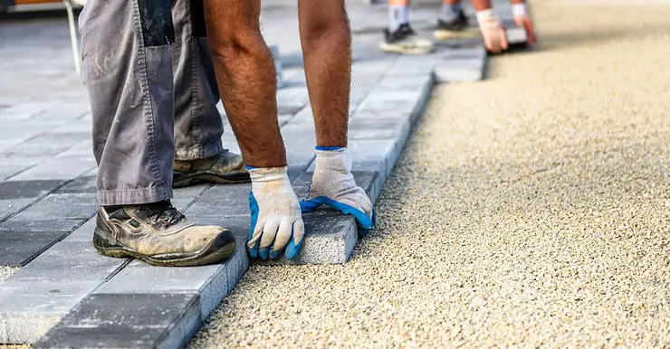 Deux hommes installent de nouvelles dalles pour l'allée