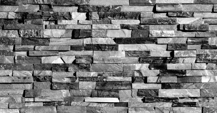Un mur de blocs de pierre noirs et gris