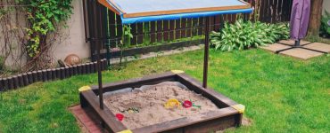 Bac à sable pour enfants avec toit dans le jardin