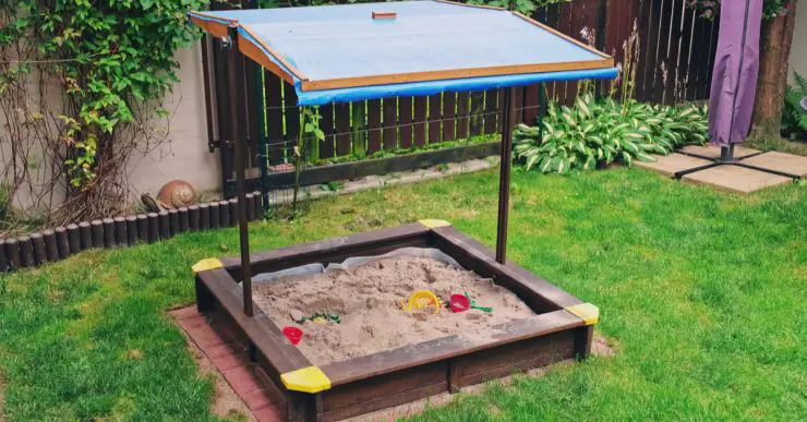 Bac à sable pour enfants avec toit dans le jardin
