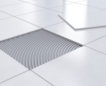 Un carreau enlevé sur un sol carrelé blanc