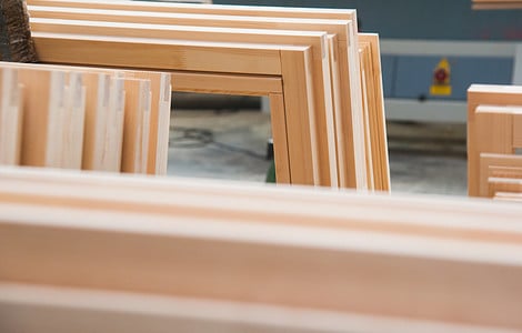 Plisoeirs fenêtres en bois empilées dans un atelier