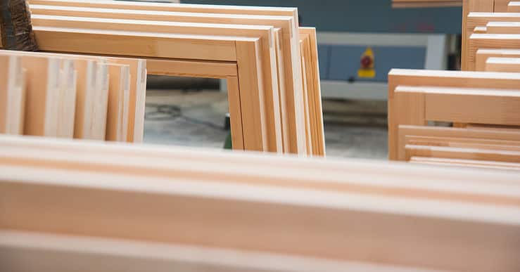 Plisoeirs fenêtres en bois empilées dans un atelier