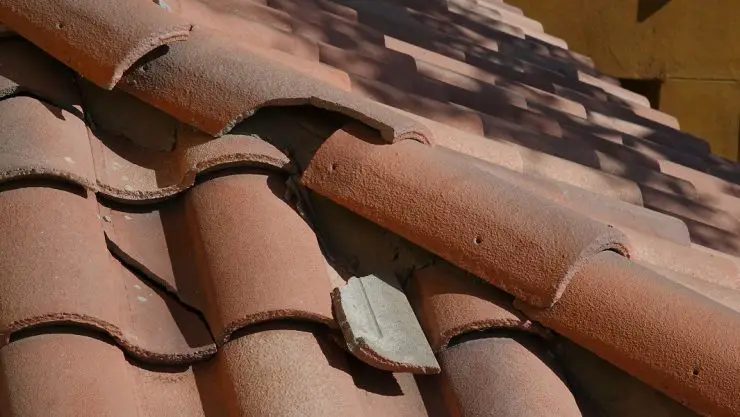 Vue sur une toiture en tuile avec une partie de tuiles cassées