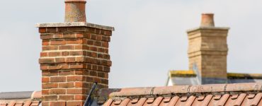 Vue sur des cheminées en briques sur une toiture en tuiles