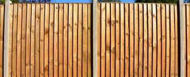 Une clôture de jardin en bois avec des poteaux d'appui en béton