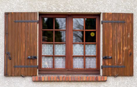 Une fenêtre vitrée en bois avec des volets
