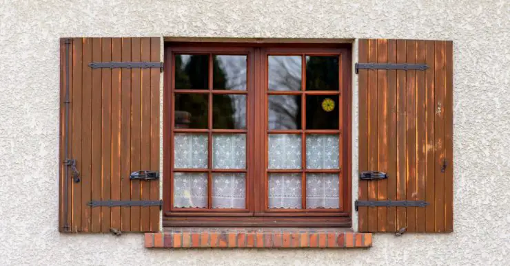Une fenêtre vitrée en bois avec des volets