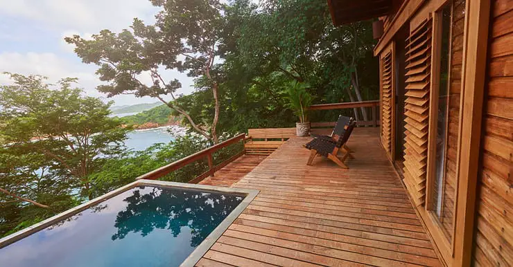 Une maison en bois avec une terrasse en bois et une piscine extérieure