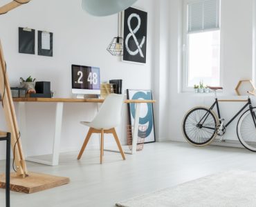 Un coin bureau aménager dans une pièce, avec un vélo rangé à côté