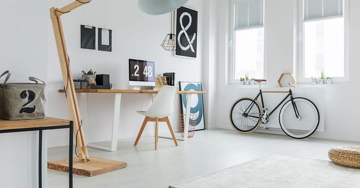 Un coin bureau aménager dans une pièce, avec un vélo rangé à côté