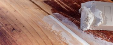 Sceller les fissures d’un plancher en bois avec de la pâte blanche