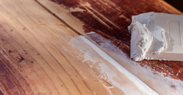 Sceller les fissures d’un plancher en bois avec de la pâte blanche