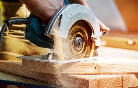 Un homme en train de couper une planche de bois avec une scie circulaire