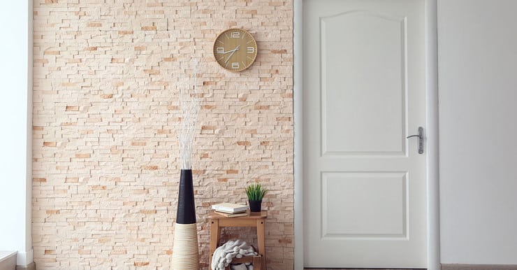 Vue sur un mur intérieur avec une partie en briquettes et une autre peinte en blanc