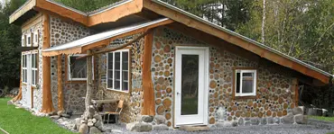 Une petite maison en bois cordé dans la forêt