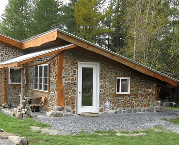 Une petite maison en bois cordé dans la forêt