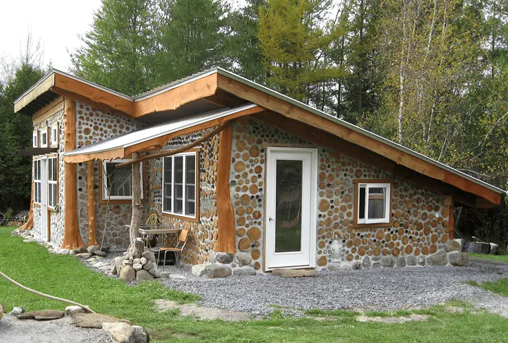 Une petite maison en bois cordé dans la forêt