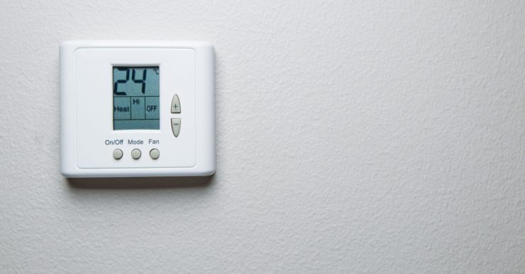 Un thermostat fixé sur un mur blanc