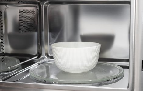 Un bol blanc placé dans un four micro-ondes ouvert
