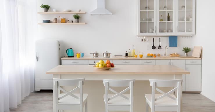 Une table à manger en bois et des chaises blanches dans une cuisine