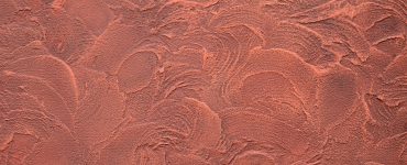 Texture d'un mur en plâtre décoratif rouge