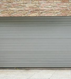 Vue sur une porte de garage à enroulement et des murs en pierre