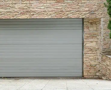 Vue sur une porte de garage à enroulement et des murs en pierre