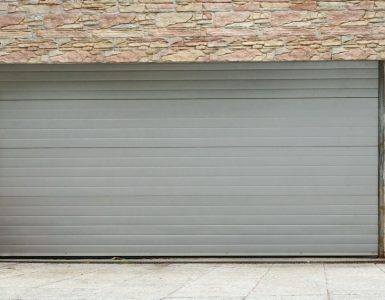 Vue sur une porte de garage à enroulement et des murs en pierre