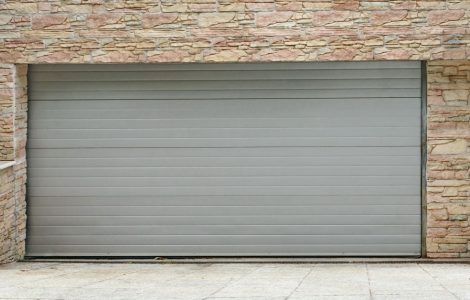 Vue sur une porte de garage à enroulement et des murs en pierre
