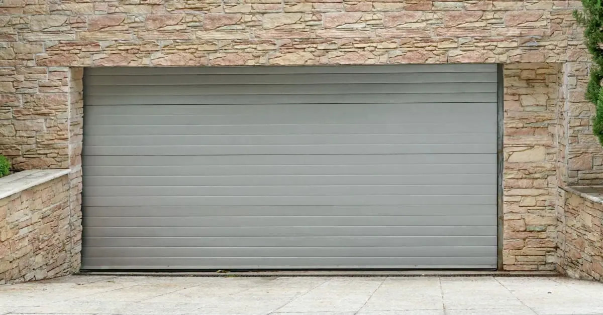 Vue sur une porte de garage à enroulement et des murs en pierre